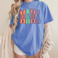 A woman wearing a blue t-shirt with the word "MAMA" printed on it, standing in front of a plain background.