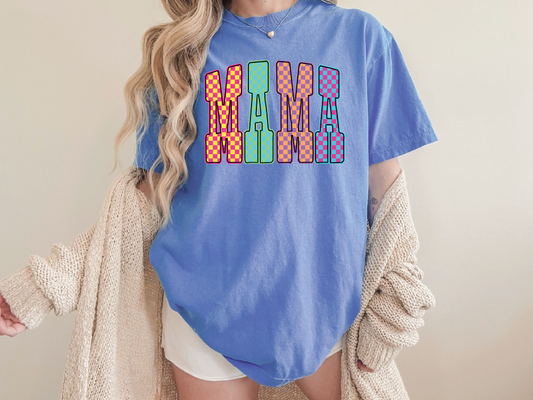 A woman wearing a blue t-shirt with the word "MAMA" printed on it, standing in front of a plain background.