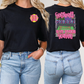 two women wearing black t - shirts with donuts on them