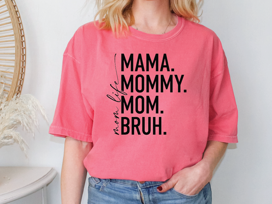 a woman wearing a pink shirt that says mama, mommy, and bruh