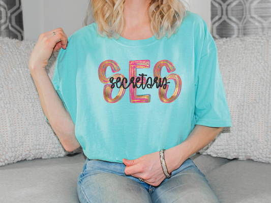 a woman sitting on a couch wearing a turquoise shirt