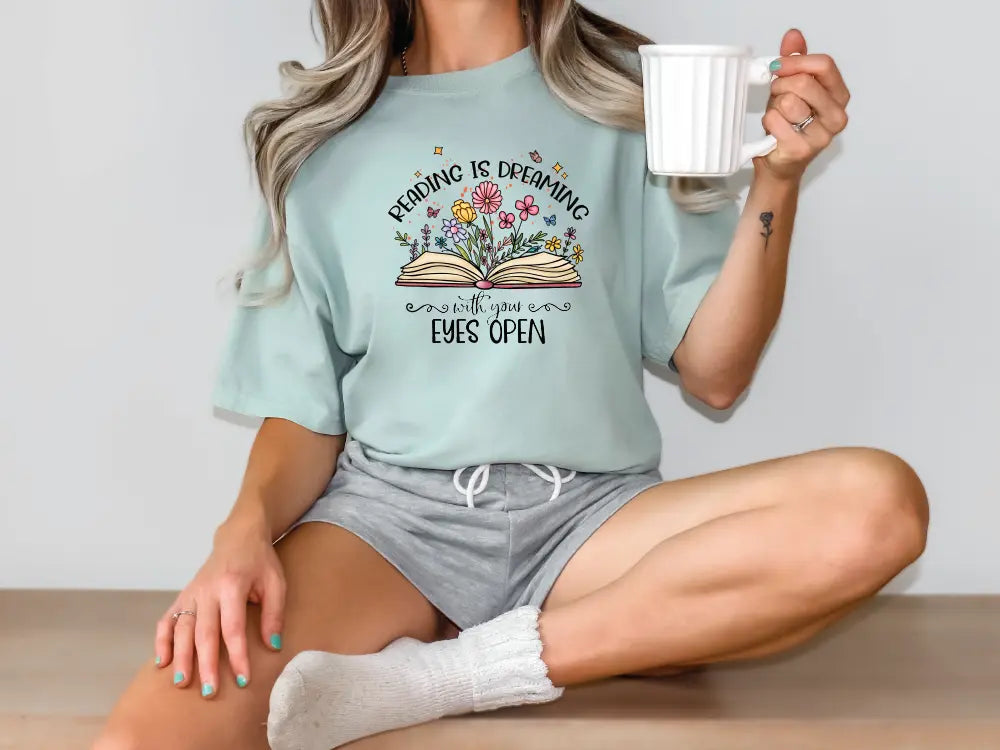 a woman sitting on the floor holding a cup of coffee