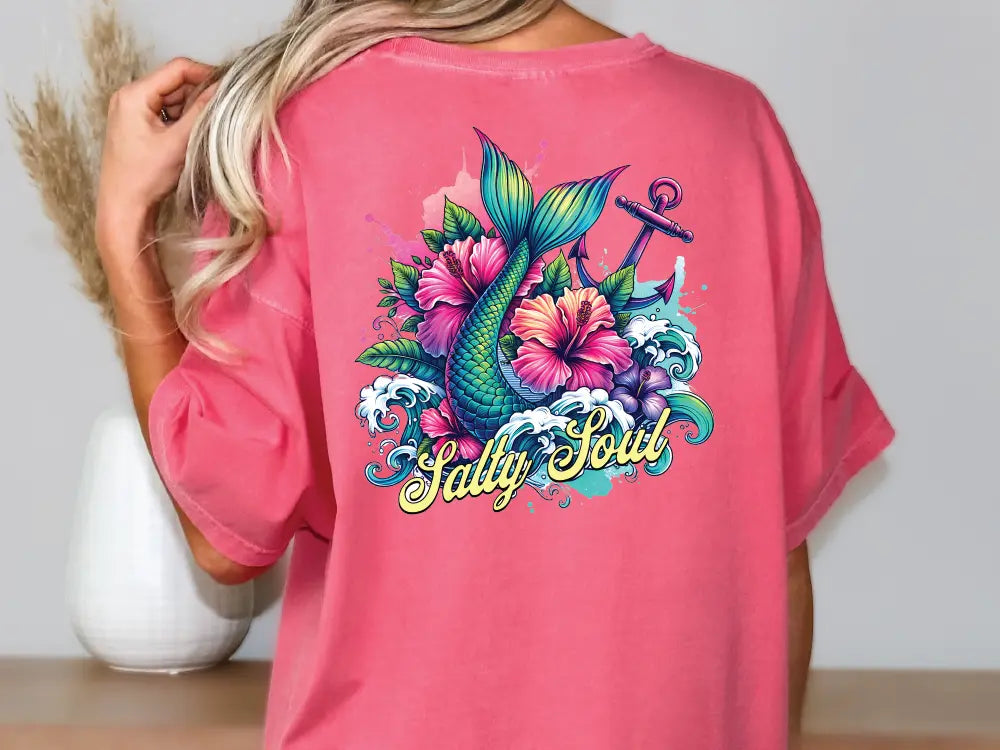 a woman wearing a pink shirt with a fish and flowers on it