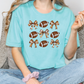 a woman sitting on a couch wearing a t - shirt with footballs on it