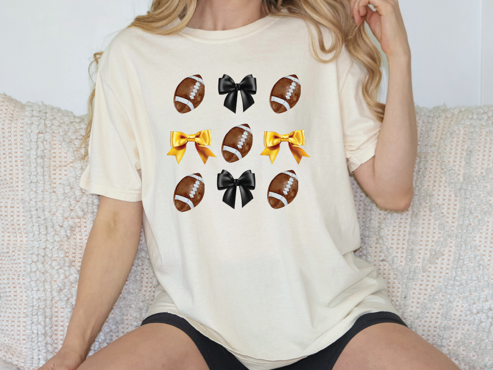 a woman sitting on a couch wearing a shirt with footballs on it