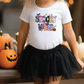 a little girl wearing a happy halloween shirt