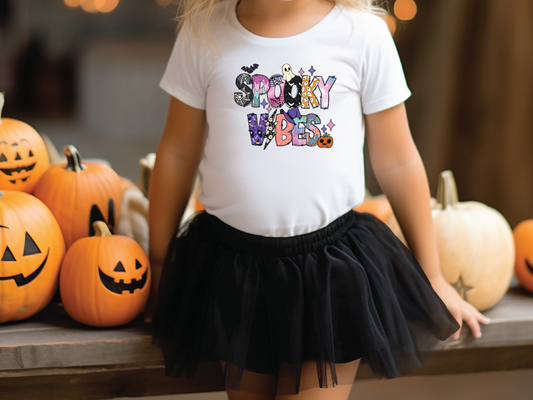 a little girl wearing a happy halloween shirt