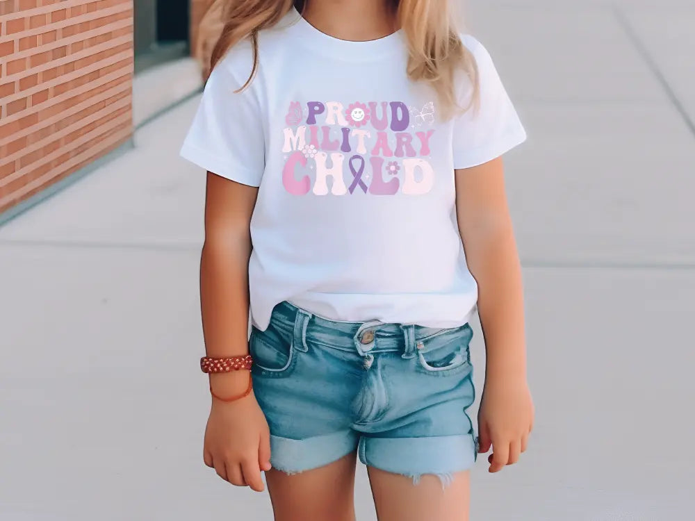 a little girl wearing a white shirt and denim shorts