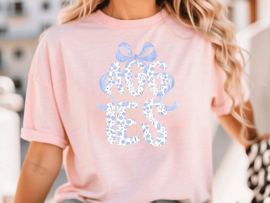 A woman wearing a pink t-shirt with the text "AGIES YES" printed on it.