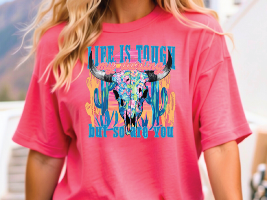 a woman wearing a pink shirt with a bull's head on it
