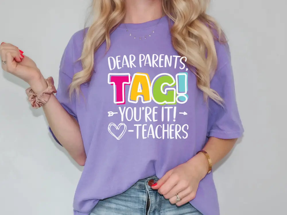 a woman wearing a purple shirt that says dear parents tag you're it teachers