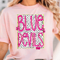 A woman wearing a pink t-shirt with the text "BLUE DEVILS" printed on it.
