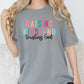 a woman wearing a t - shirt that says raising kids and trying god