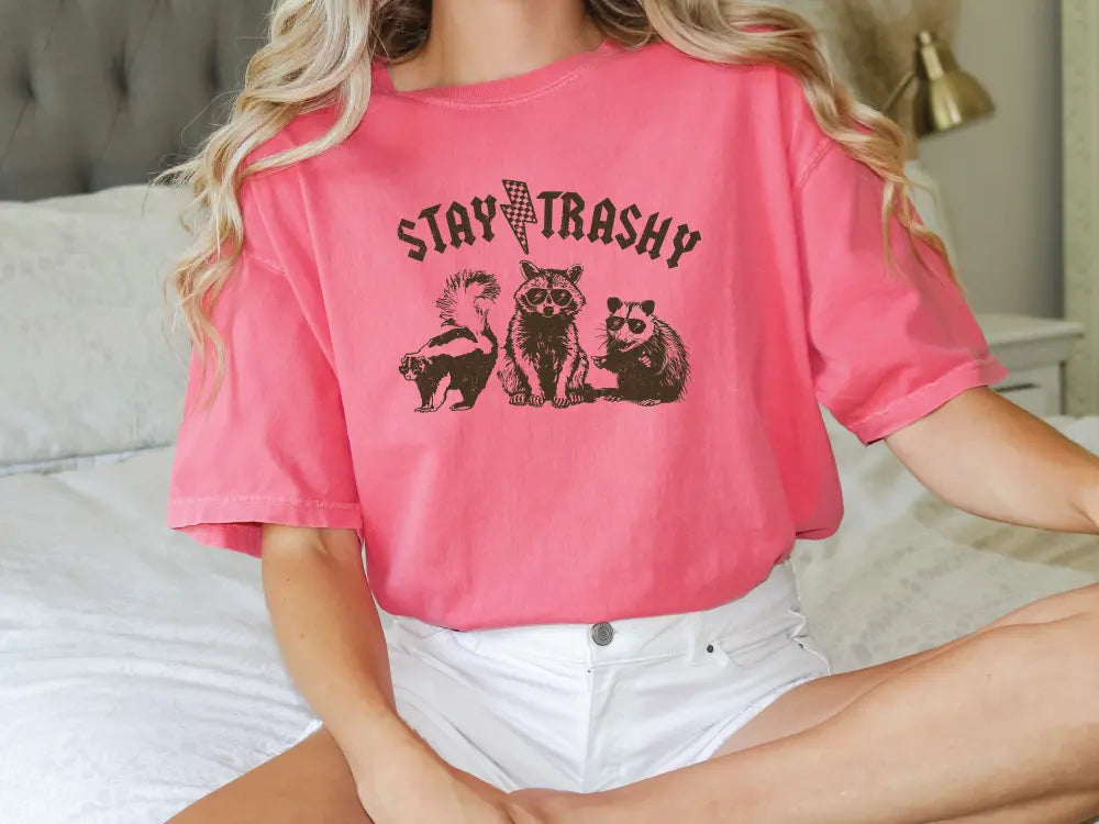 a woman sitting on a bed wearing a pink shirt