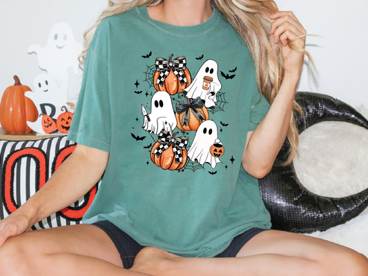 A woman wearing a green t-shirt with a Halloween-themed graphic of ghostly figures and pumpkins.