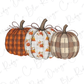 Three decorative pumpkins with different patterns and colors are arranged in a row.