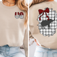 The image is a collage of two photos. In the left photo, a woman is wearing a beige sweater with a red and white pattern on the front and the letters 'VA' on the left side. In the right photo, the woman is wearing a beige sweater with a red and white pattern on the back and a black elephant silhouette.