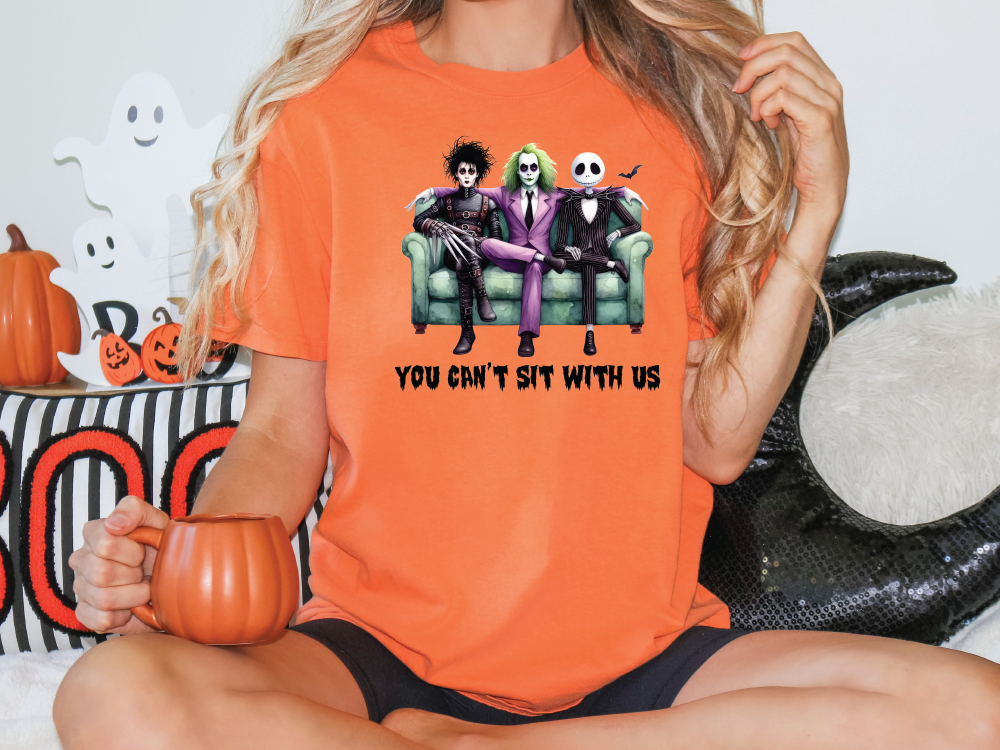 a woman sitting on a couch wearing an orange shirt