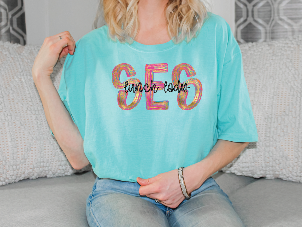 a woman sitting on a couch wearing a turquoise shirt