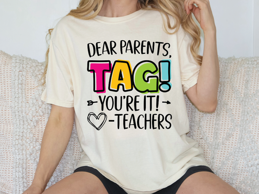 a woman sitting on a couch wearing a t - shirt that says dear parents tag