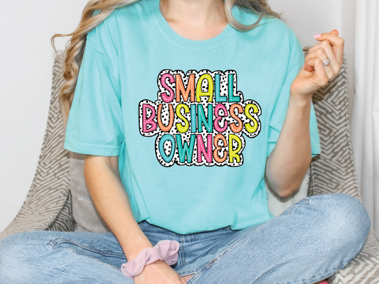 a woman sitting on a couch wearing a small business owner t - shirt