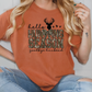 a woman wearing an orange shirt with a deer on it