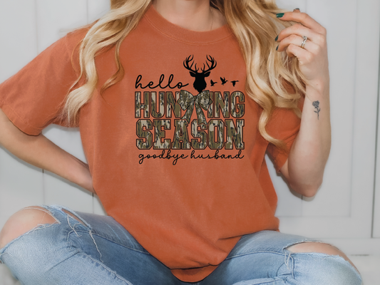 a woman wearing an orange shirt with a deer on it