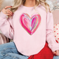 a woman wearing a pink sweatshirt with a heart painted on it