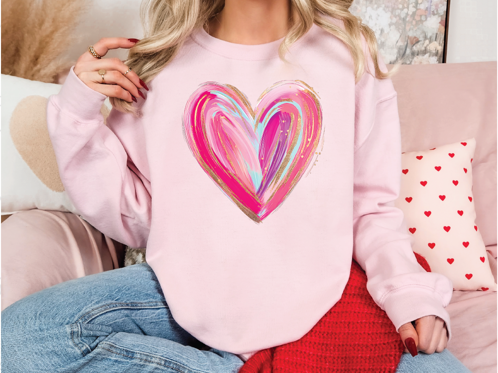 a woman wearing a pink sweatshirt with a heart painted on it