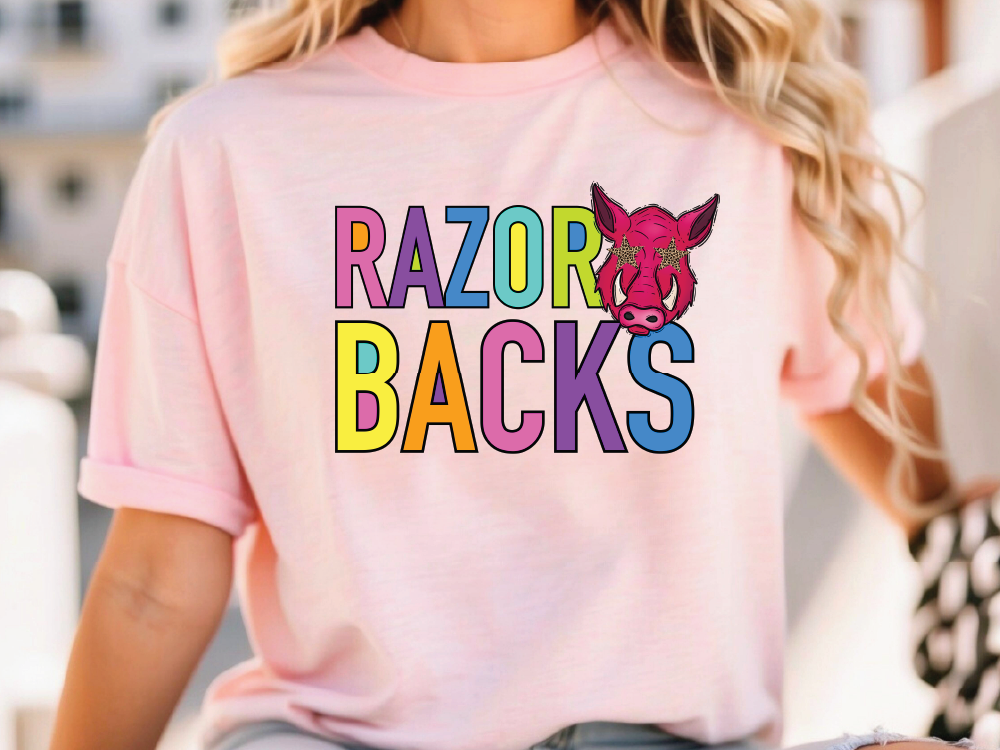 A woman wearing a pink t-shirt with the text "RAZOR BACKS" printed on it.