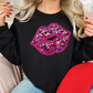 a woman wearing a black sweater with pink and purple glitter lips on it