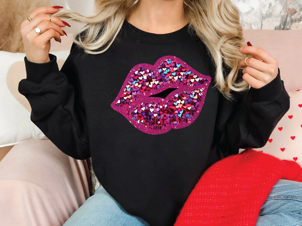 a woman wearing a black sweater with pink and purple glitter lips on it