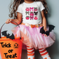 a little girl in a halloween costume holding a trick or treat bucket