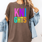 A person wearing a brown t-shirt with the text "KNIGHTS" in colorful letters, along with a denim jacket, stands against a white background.
