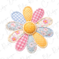 A colorful patchwork flower made of various fabric pieces in pastel shades, including blue, pink, yellow, and white polka dots.