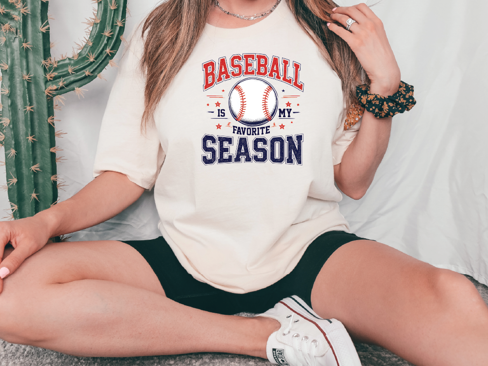 a woman sitting on the ground wearing a baseball is my favorite season t - shirt