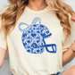 A woman wearing a white t-shirt with a blue and white floral design on it.