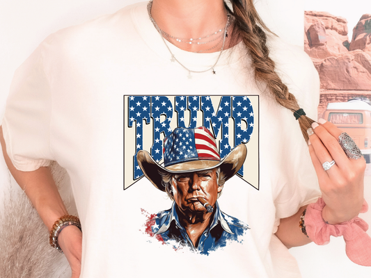a woman wearing a trump t - shirt holding a brush