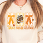 A woman wearing a white sweatshirt with a graphic design featuring a football, autumn leaves, and the text "TOUGH DOWN SEASON".