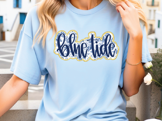A woman wearing a light blue t-shirt with the word "Blue Tide" printed on it.