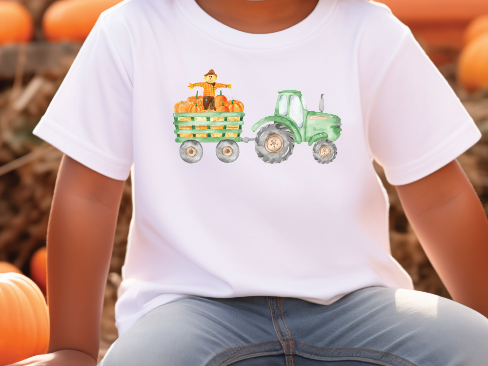 a young boy sitting on a pumpkin patch