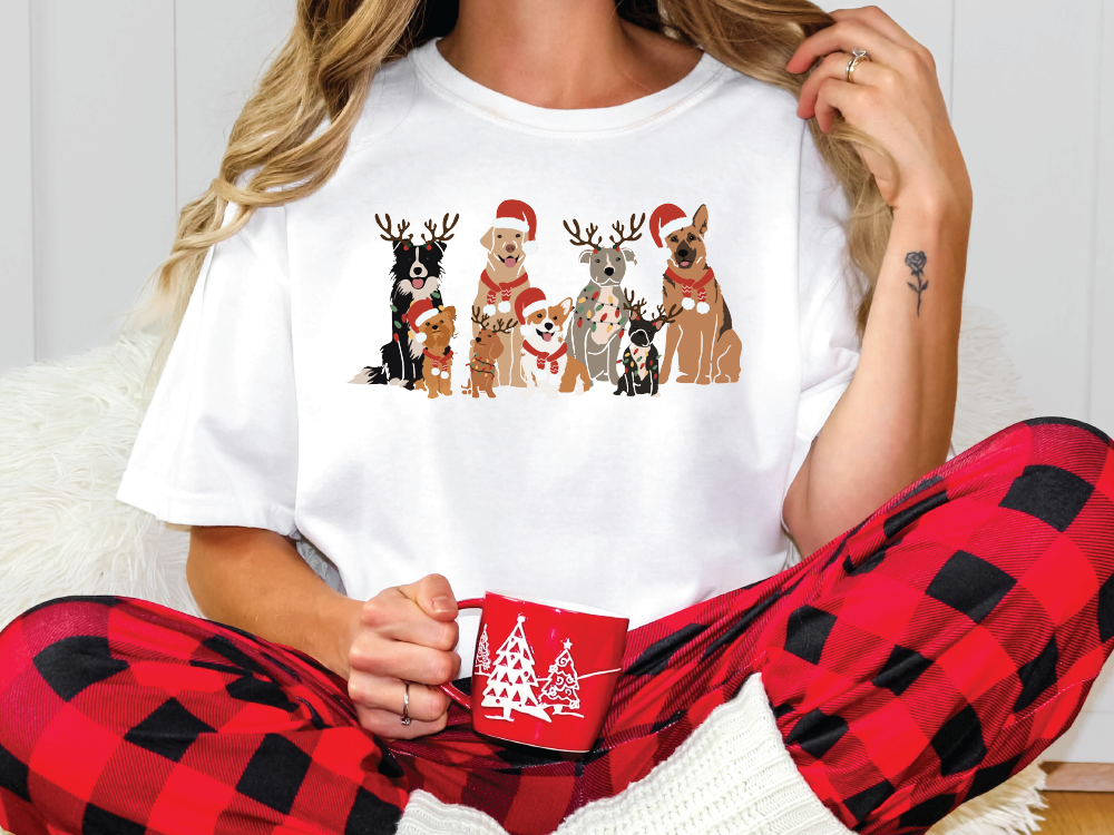 a woman sitting on the floor wearing pajamas and a t - shirt with reindeers