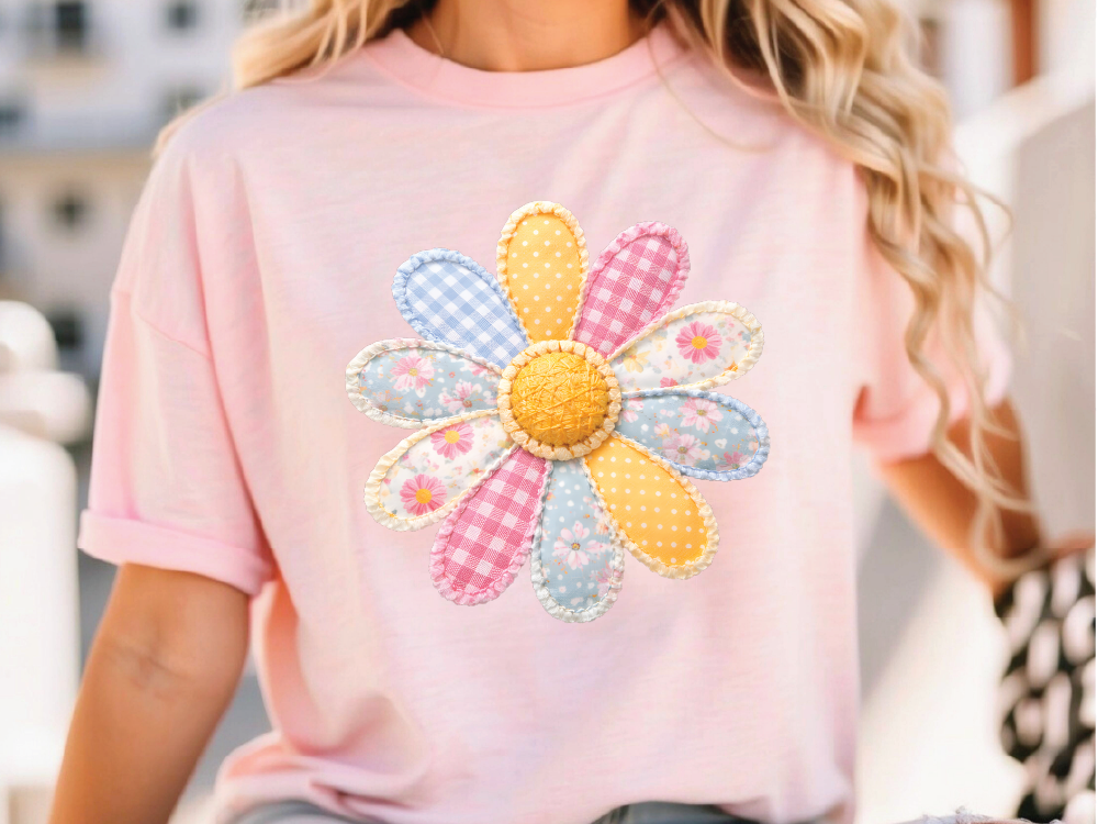 A woman wearing a pink t-shirt with a colorful flower design on it.