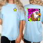 two women wearing light blue t-shirts with a graphic design featuring a stylized eagle and colorful elements.