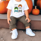 a little boy sitting on a step next to pumpkins