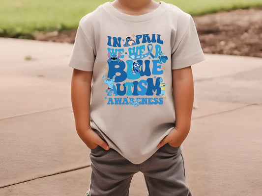 a young boy standing on a sidewalk wearing a t - shirt