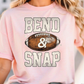A woman wearing a pink t-shirt with the text "BEND & SNAP" printed on it.