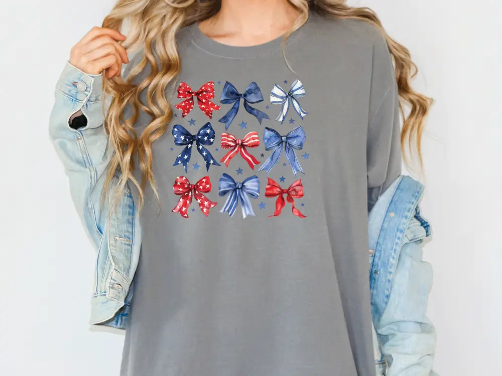 a woman wearing a gray shirt with red, white and blue bows on it