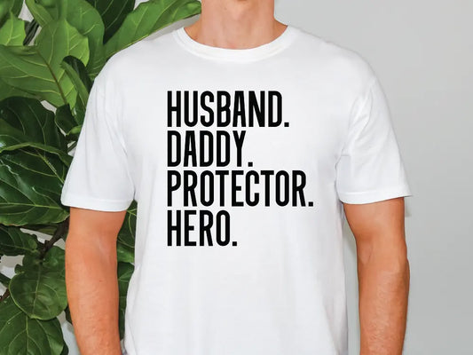 a man standing in front of a plant wearing a t - shirt that says husband