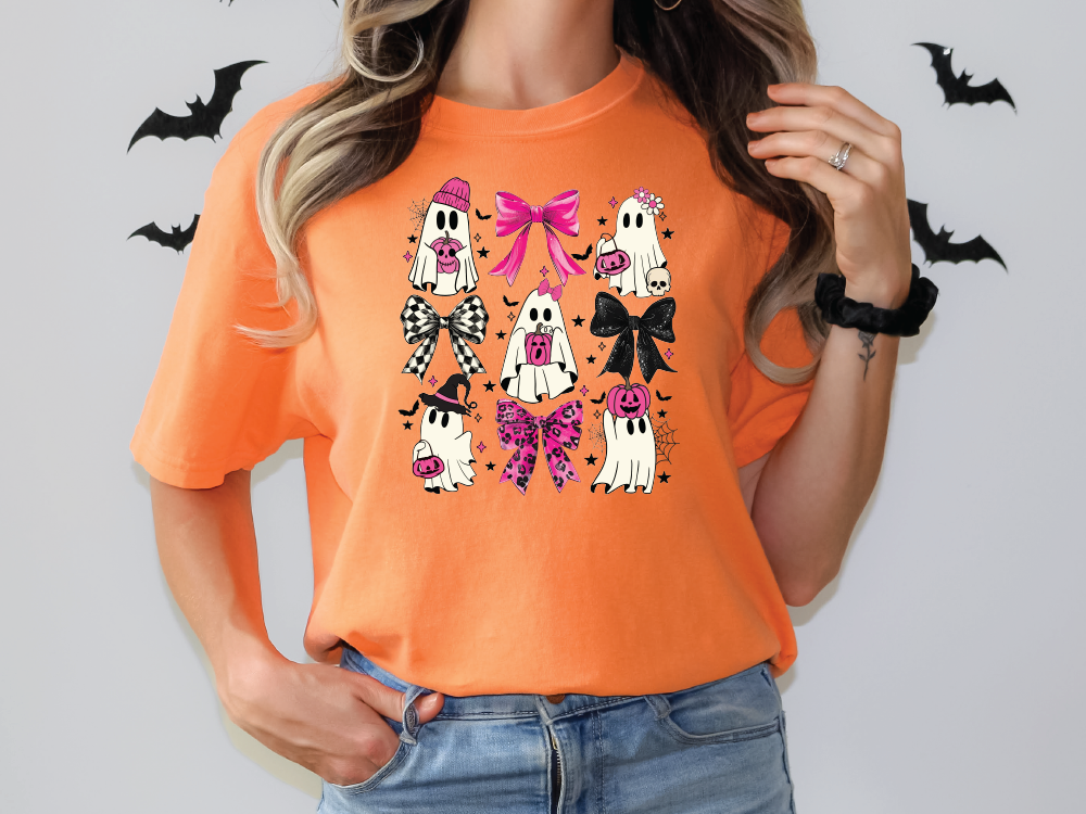 a woman wearing an orange shirt with halloween decorations on it